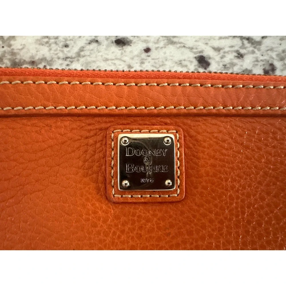 Dooney & Bourke pebble grain large slim wristlet bag in orange